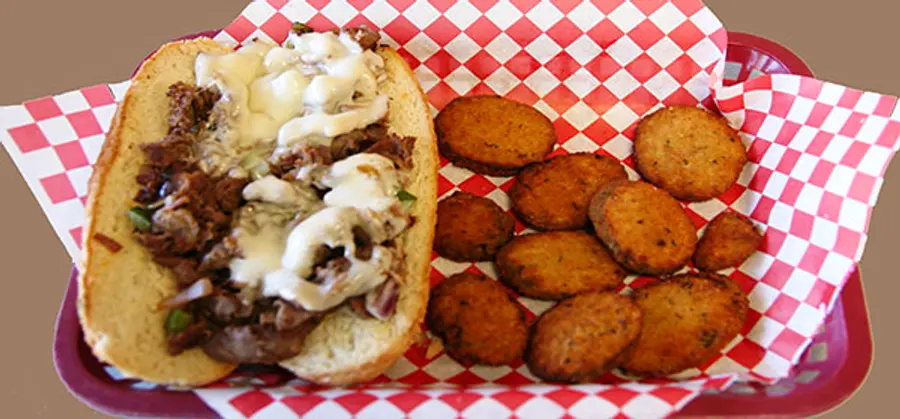 The Breakfast Philly on a hoagie roll with fried zucchini in a red-checkered basket